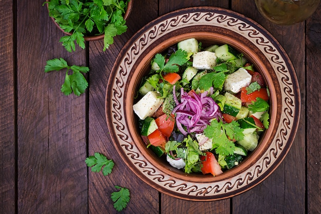 Vegetarian salad with cherry tomato, brie cheese, cucumber, cilantro and red onion. American cuisine. Top view. Flat lay