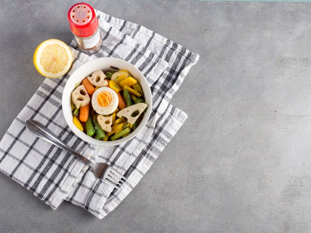 Vegetarian salad with lemon on grey table