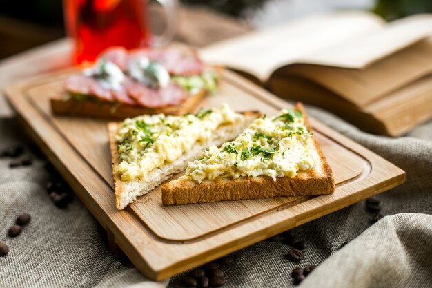 Вегетарианский сэндвич тост хлеб пюре из зелени на деревянной доске вид сбоку