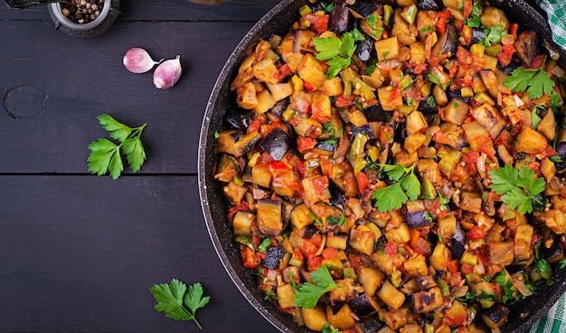 Vegetarian stew eggplants, bell peppers, onions, garlic and tomatoes with herbs