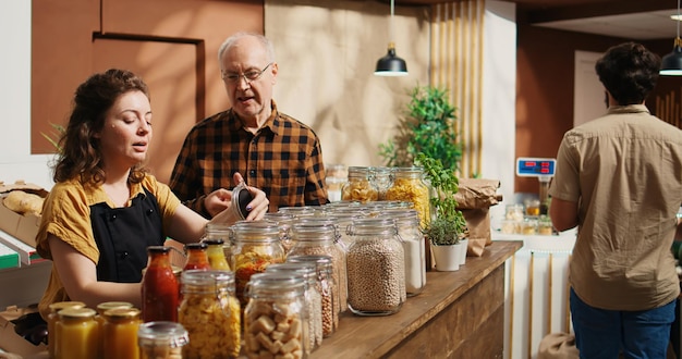 Free photo vendor assists old client in food shop