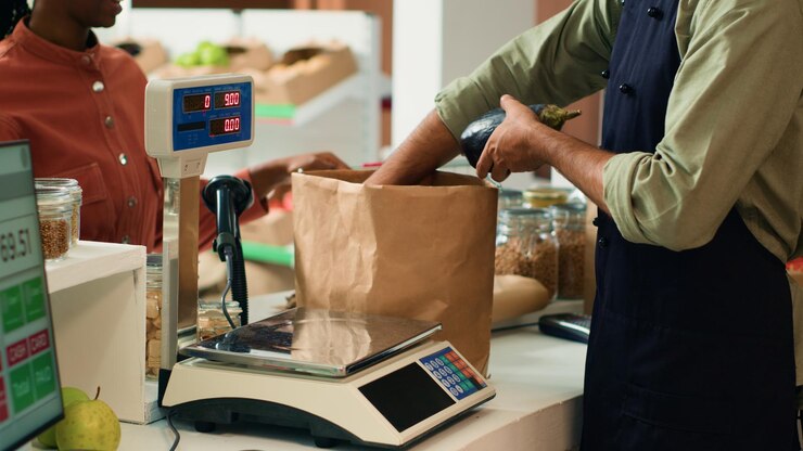Free Photo vendor weighting fresh produce for buyer