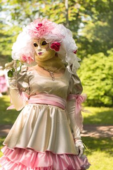베네치아 카니발. 장미와 핑크 드레스와 안면 마스크에 여자