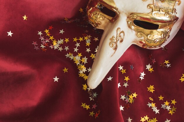 venetian mask with a long nose and star confetti
