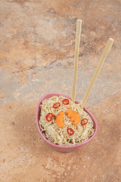 Vermicelli with spices and pepper slices on orange space. 