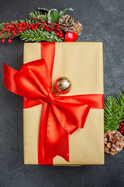 Vertcal view of Christmas background with beautiful gifts with bow-shaped ribbon and fir branches decoration accessories on a dark table