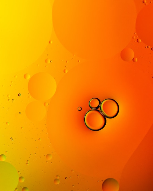 オレンジ色の泡または液滴の垂直方向の抽象的な背景