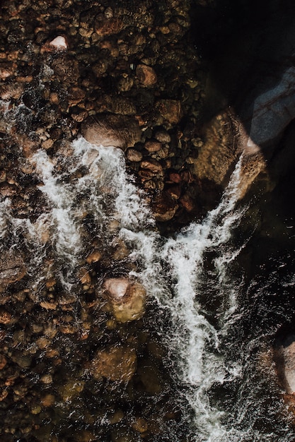 Vertical aerial shot of rocks on the body of seawater