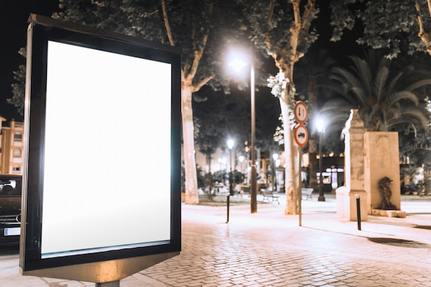 Vertical blank billboard on street at night