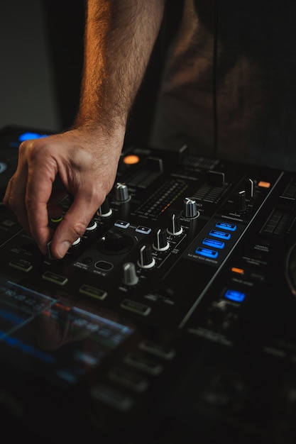 Vertical closeup of a DJ working in a nightclub