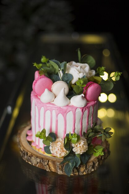 Vertical closeup shot of a beautiful cake with flowers and macaroons