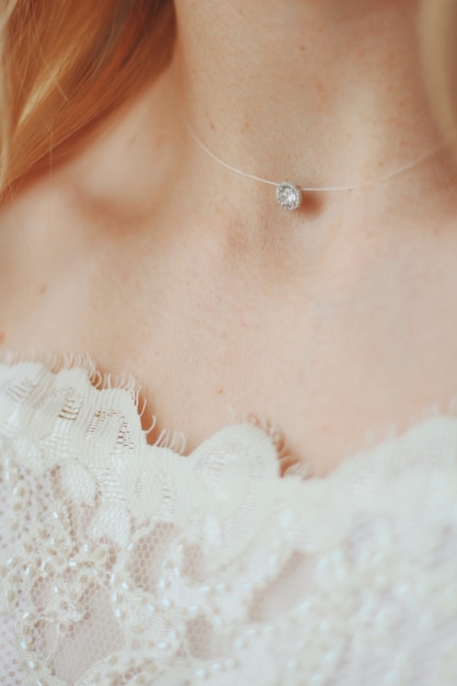Vertical closeup shot of a bride wearing a delicate choker necklace