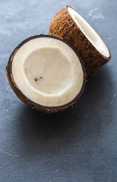 Вертикальный снимок крупным планом нарезанных кокосов на серой поверхности