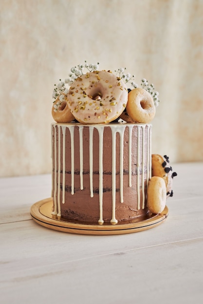 Vertical closeup shot of delicious Donut choco Birthday cake with donuts on top and white drip