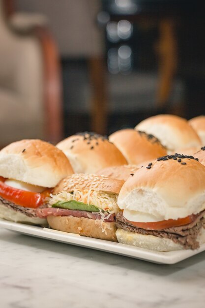 Vertical closeup shot of delicious sandwiches on a white plate on a marble table