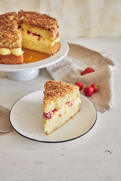 Vertical closeup shot of the delicious Vanilla cream cake with strawberries inside on a white table