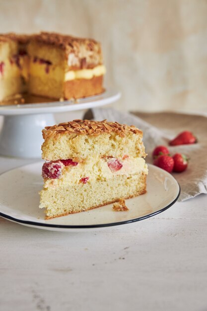 Vertical closeup shot of the delicious Vanilla cream cake with strawberries inside on a white table