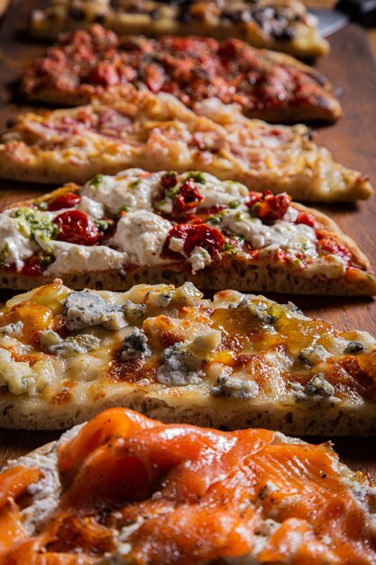 Vertical closeup shot of different types of pizza on the table