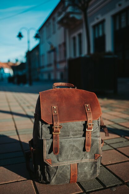 Vertical closeup shot of a grey and brown rucksack on the ground in the street