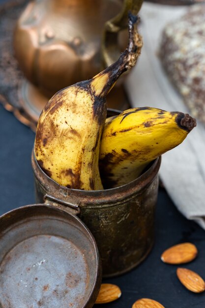 Vertical closeup shot of old bananas in a rusty can