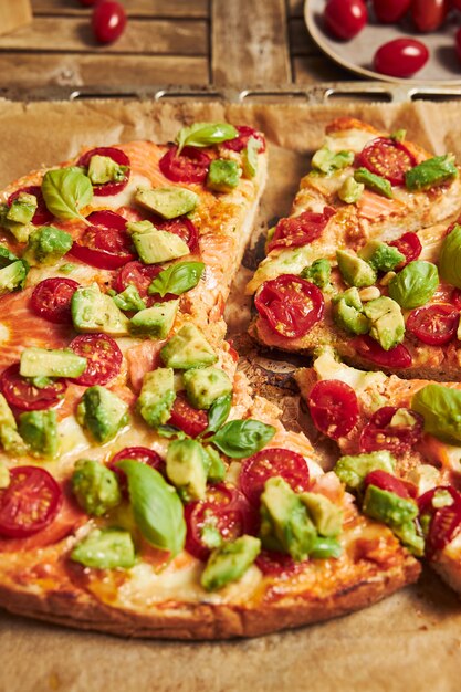 Вертикальный снимок крупным планом пиццы с овощами на деревянном столе