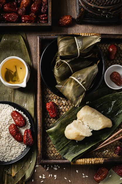 Vertical closeup shot of preparation of rice dumplings with banana leaves