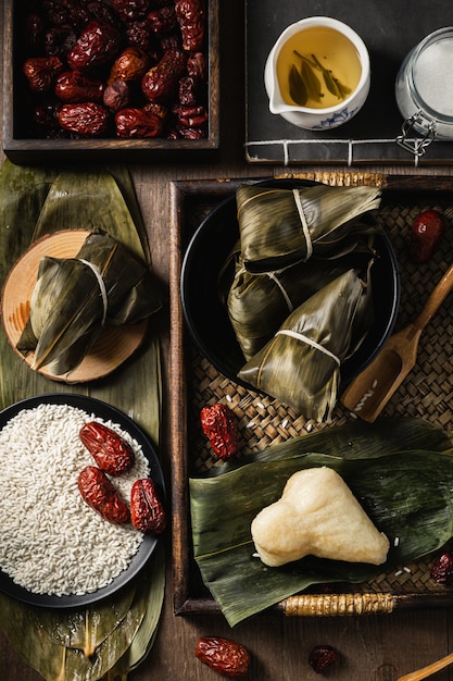 Vertical closeup shot of preparation of rice dumplings with banana leaves