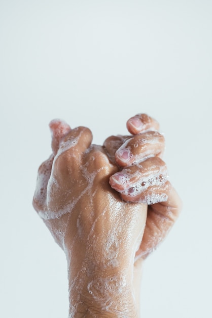 Vertical closeup shot of the soaped hands of a person