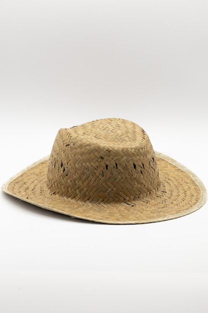 Vertical closeup shot of a straw hat isolated on a white scene