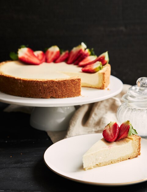 흰색 접시에 딸기 치즈 케이크의 수직 근접 촬영 샷