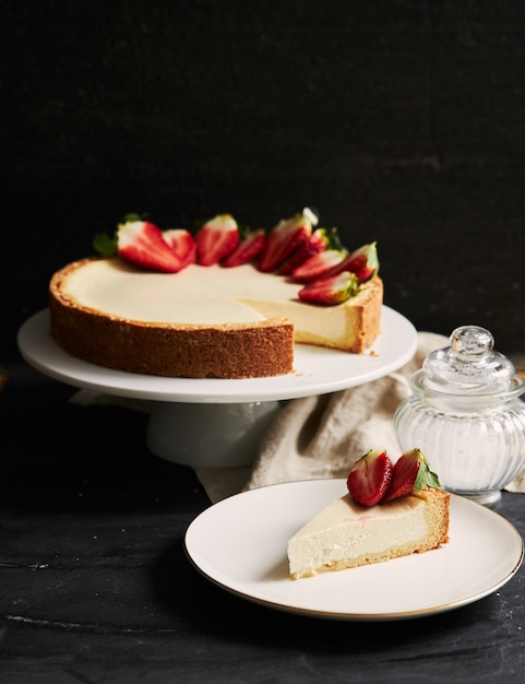 흰색 접시에 딸기 치즈 케이크의 수직 근접 촬영 샷