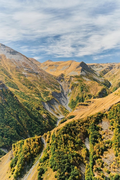 山の高原の秋からの滝のある峡谷の垂直フレーム ビュー 山でのジョージア トレッキングへのテキスト旅行用のスペースを含むバナーまたはポストカードのアイデア