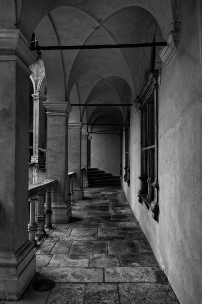 Vertical grayscale shot of a beautiful balcony of an old building with columns