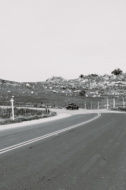 Foto gratuita colpo di gradazione di grigio verticale di una strada della campagna