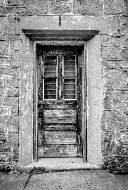 Вертикальный снимок в градациях серого двери в Восточной государственной тюрьме в Филадельфии, штат Пенсильвания.