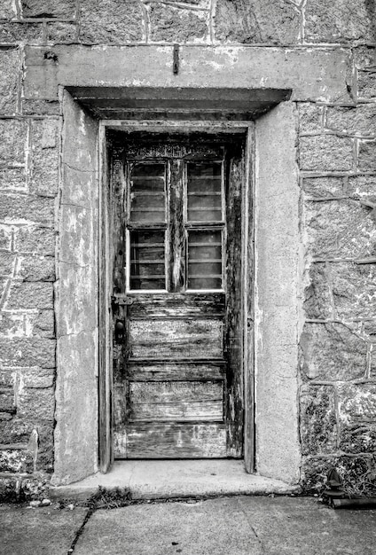 Vertical grayscale shot of a door at the Eastern State Penitentiary in Philadelphia, Pennsylvania