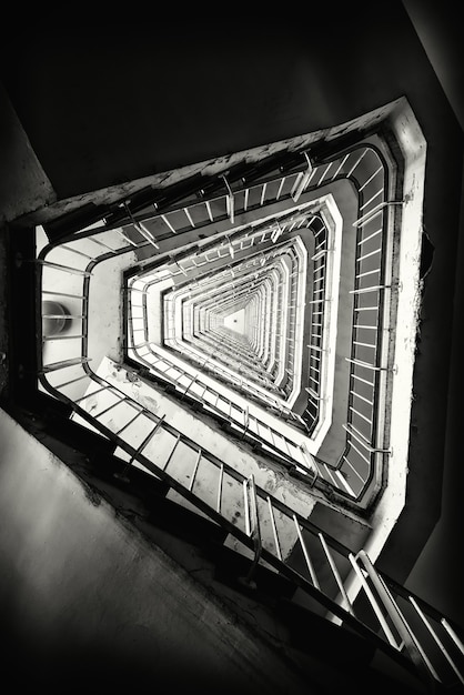 Vertical grayscale shot of a staircase in a building