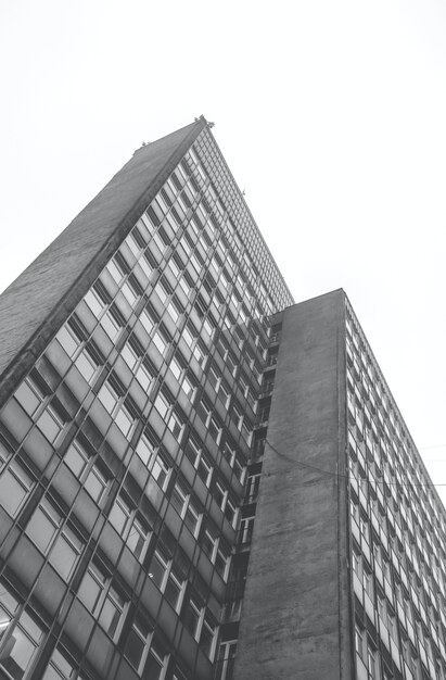 Vertical greyscale low angle shot of a residential building at daytime