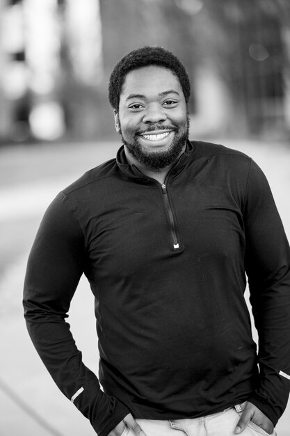 Vertical greyscale shot of an attractive African American male smiling