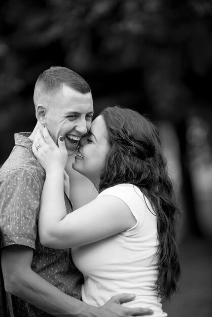 Vertical greyscale shot of a happy white couple enjoying each other's company