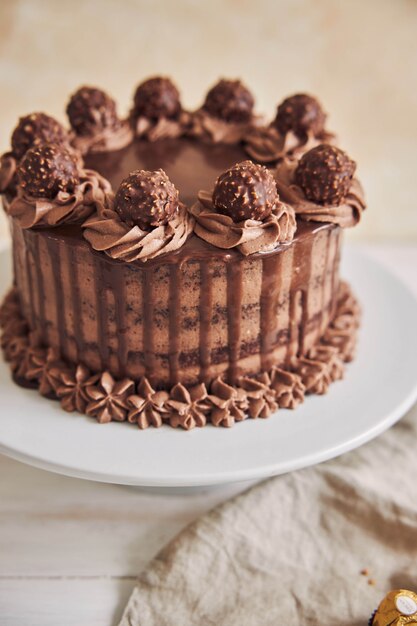 Вертикальный снимок с большим углом свежего шоколадного торта, украшенного восхитительным шоколадом на тарелке