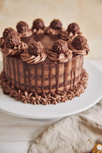 Vertical high angle shot of a fresh chocolate cake decorated with delicious chocolate on a plate