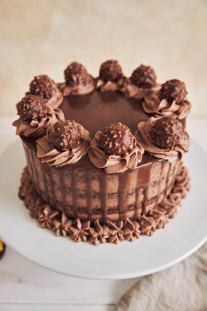 Vertical high angle shot of a fresh chocolate cake decorated with delicious chocolate on a plate