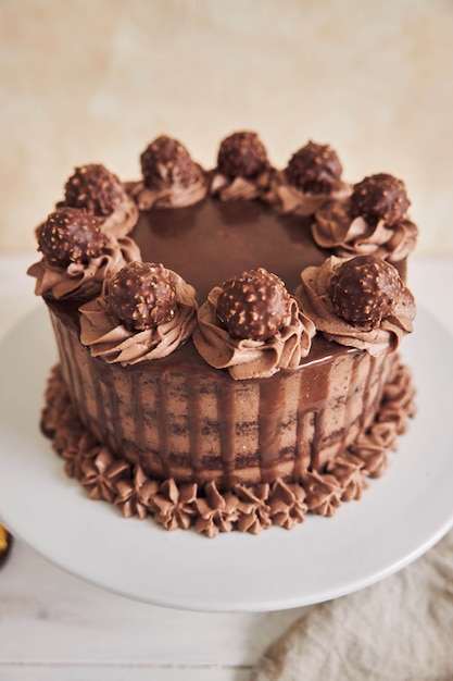 プレートにおいしいチョコレートで飾られた新鮮なチョコレートケーキの垂直ハイアングルショット