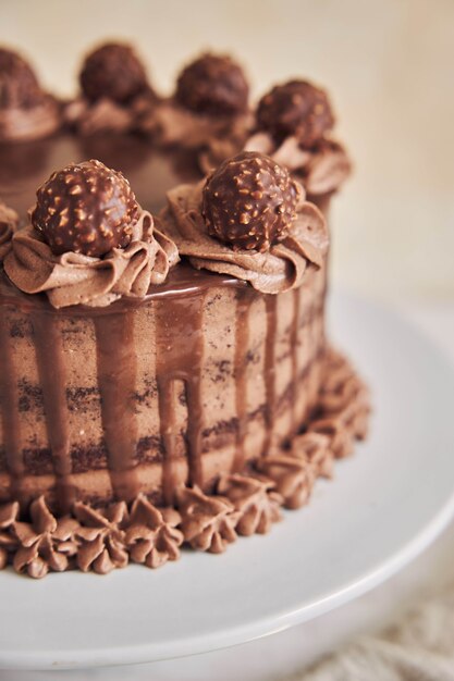 Vertical high angle shot of a fresh chocolate cake decorated with delicious chocolate on a plate