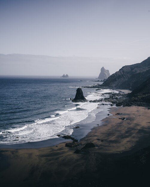 Вертикальный снимок с высоким углом каменистого берега моря в пасмурный день