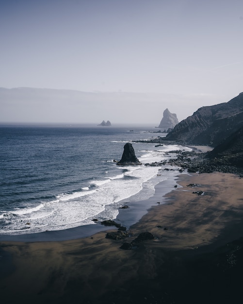 Vertical high angle shot of the rocky shore of the sea on a gloomy day