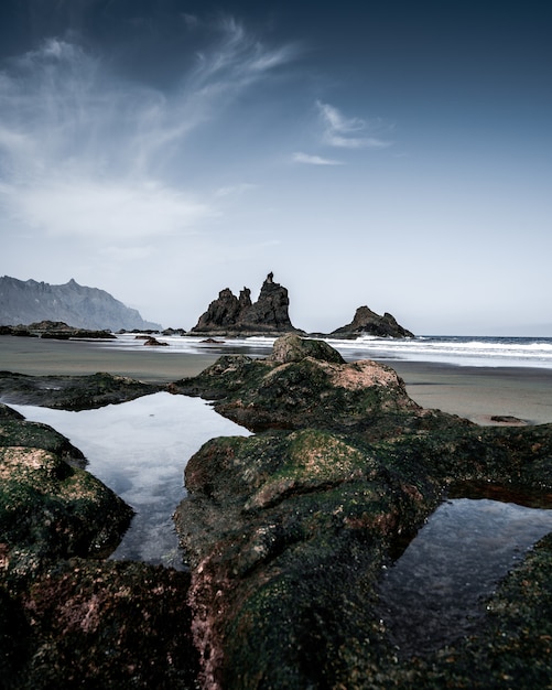 Vertical high angle shot of the rocky shore of the sea