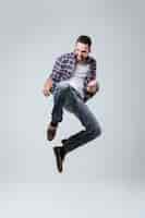 Free photo vertical image of bearded man in shirt which jumping