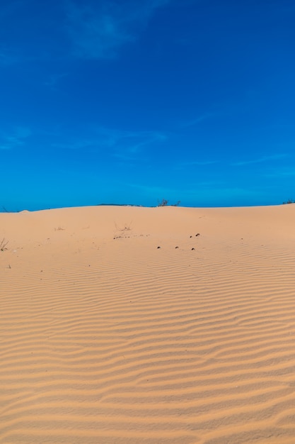 Vertical image of the beautiful sand dunes of mui ne, vientam under a clear blue sky